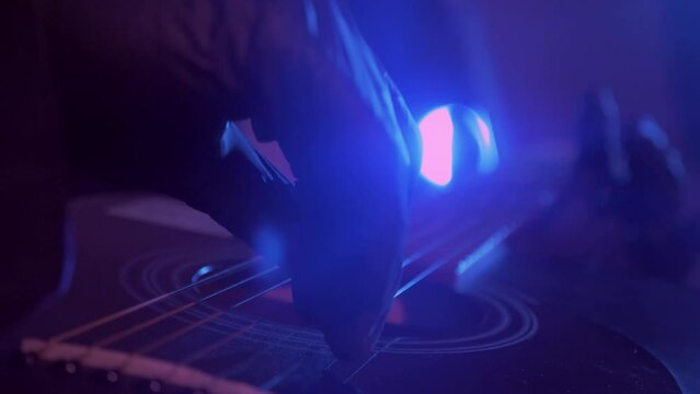 The devil monster plays the guitar. A mystical man in a scary mask in a dark studio. Horror, Halloween, Hell