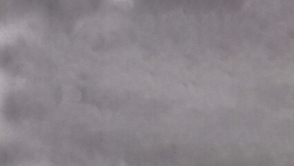 A gray cloudy sky, with a mix of light and dark gray clouds covering the entire sky, abstract background