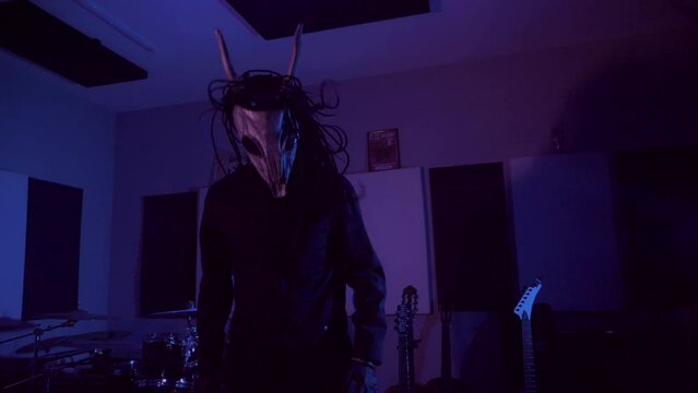 Devil monster suffers, dances, gets angry. A mystical man in a scary mask in a dark studio. Horror, Halloween, Hell