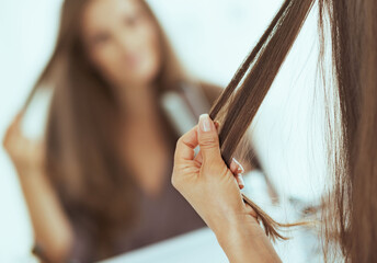 Closeup on woman checking hair after straightening