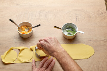 Hand preparing tortellini pumpkin and broccoli