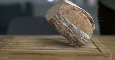 Falling traditional rustic bread captured with camera with flour and crumbs flying in the air