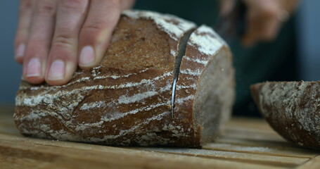 Capture of Bread Being Sliced with Flying Crumbs and flour with knife