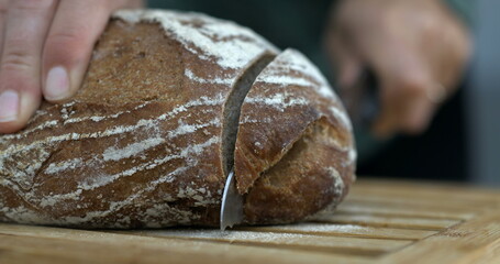 Capture of Bread Being Sliced with Flying Crumbs and flour