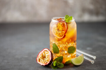 Fruit ice tea. Refreshing summer drink with syrup, passion fruit, lime, mint and ice. Glass with...