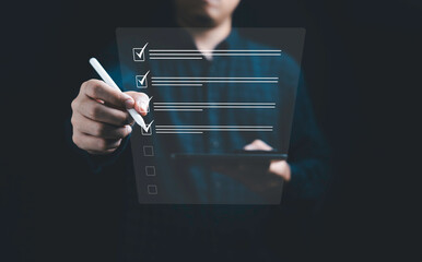 Businessman using electronic pen to tick correct sign mark in online document checklist for quality...