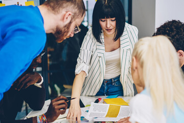 skilled diversity crew checking business plan on meeting table