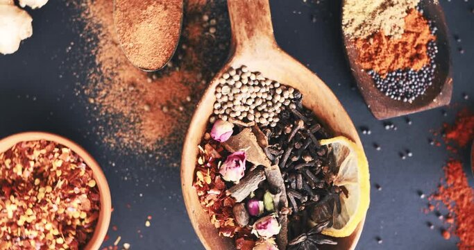 Spices, herbs and condiment for advertising, table and table for curry, wooden spoons and seasoning. Food, natural or different for organic, chilli or marketing for ingredients, dark backdrop or dry