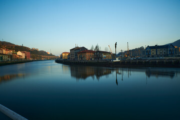 Fototapeta na wymiar Early morning in Zorrozaurre District in Bilbao seen from the other side of the River Nervión