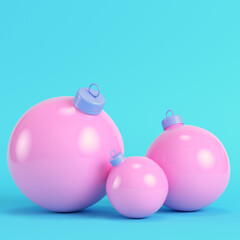 Pink three christmas bubles on bright blue background in pastel colors