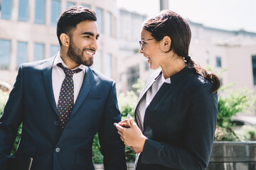 happy multicultural man and woman in formal wear communicate outdoors
