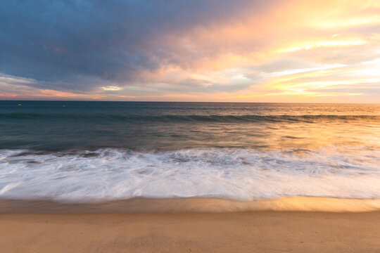 Cloudscape and seascape at ocean sunset with sandy beach in Portugal
