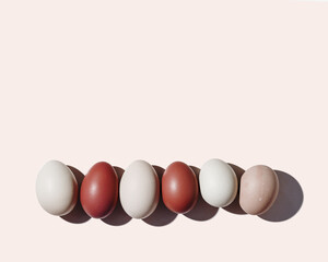 Easter eggs red gradient color in row with hard Shadow at sunlight, pink background. Chicken eggs minimal flat lay, traditional food and symbol of Easter, monochrome colored, top view,