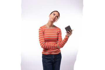 Naklejka premium caucasian stylish young black-haired woman with a ponytail dressed in an orange jacket watches a video on the phone