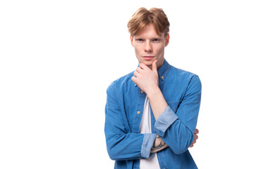 portrait of a pensive caucasian red-haired guy in a denim blue shirt