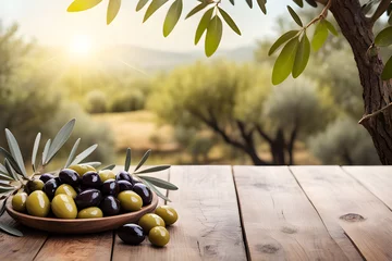 Fototapeten Wooden table with olive fruits and olive tree on nature background © HalilKorkmazer