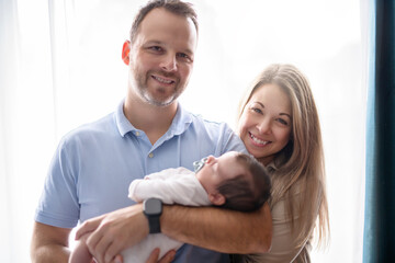 father and mother on bedroom with his newborn baby son