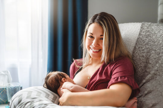 woman breastfeeding baby using a breastfeeding pillow