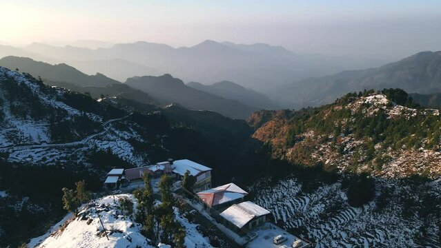 Aerial view of beautiful snow-covered mountains during winters in the Himalayan region of Uttarakhand. First Snowfall in Dhanaulti, India. Hill station covered in snow. Foothills of Himalayas.