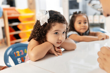 Little hispanic girl learning in a classroom.