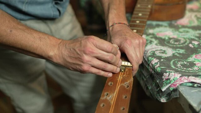 Luthier Clears Residual Dust from Guitar Neck