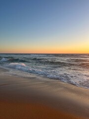 Orange sea horizon, sandy coastline, evening seascape reflection, pastel colors