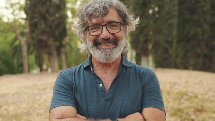 Close-up of an elderly man crossing his arms and looking at the camera with smile - Powered by Adobe