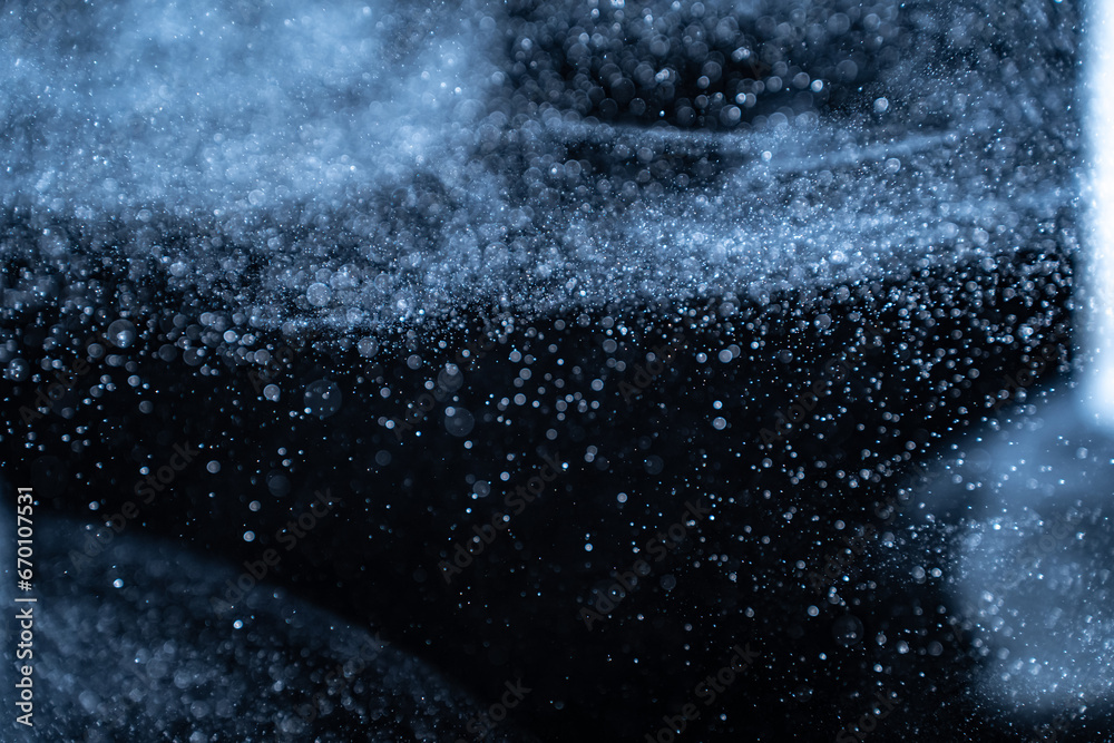 Wall mural blue particles on black background with cinematic atmosphere. glittering sparkling bokeh overlay wit