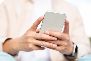 Businessman hands holding smartphone, typing email, chatting, cropped