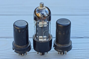 three different whole glass and black iron  retro electric historical vacuum radio tubes with metal...