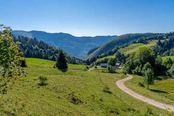 Chézery-Forens, France - 09 02 2021: View of the landscape with hills, meadows, forests, a path...