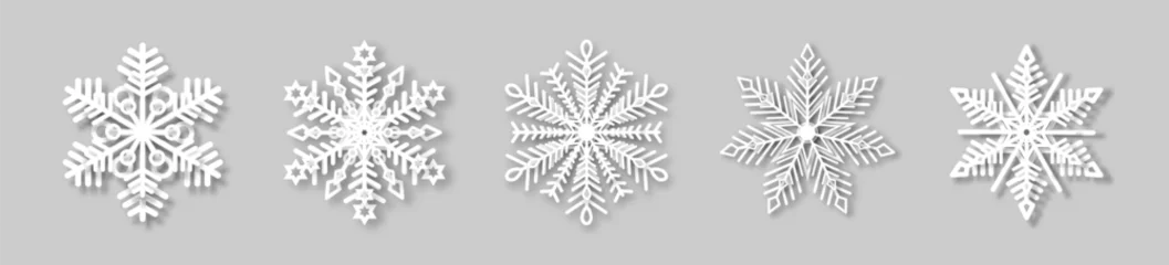 Fotobehang A set of white snowflakes with a paper effect and a shadow on a gray background. The element of Christmas and New Year. The symbol of winter. Vector illustration. © Helga1