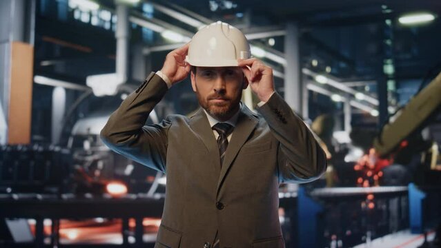 Business man wearing helmet in industrial factory closeup. Production specialist