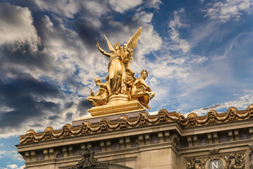 Fototapeta na wymiar Golden statue of Liberty on the roof of the Opera Garnier (Garnier Palace) against the sky at sunset. Sculpted by Charles Gumery in 1869. Paris, France. UNESCO World Heritage Site