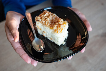 The woman holds food in her hand. the girl holds in her hands. Cake on plate.