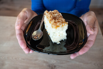 The woman holds food in her hand. the girl holds in her hands. Cake on plate.