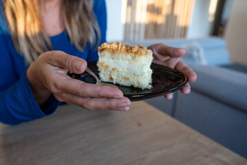 The woman holds food in her hand. the girl holds in her hands. Cake on plate.