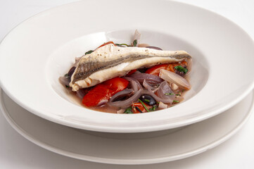 White fish on a bed of tomatos and onions