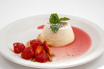 Panacotta and strawberries on a plate.