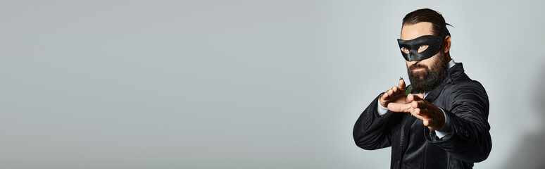 Christmas Masquerade, handsome bearded man in carnival mask and suit on grey backdrop, banner