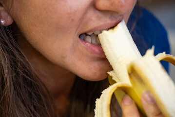 Woman eats food. Woman eats  banana. Close shot of girl eating  bananas. Face while eating bananas