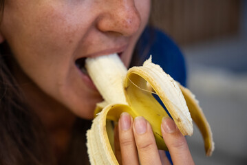 Woman eats food. Woman eats  banana. Close shot of girl eating  bananas. Face while eating bananas