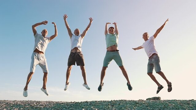 Men jumping up against blue sky