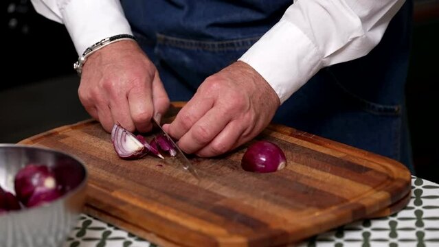 the chef cuts the Tropea onions with the knife
