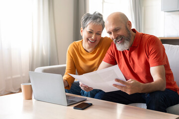 Happy Senior Spouses Checking Financial Documents And Calculating Family Budget At Home