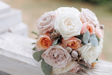 Bouquet of pink and white roses with a ribbon on a beige background. Concept for expressing love, gratitude, wedding or congratulation. Copy space for greeting card or invitation.