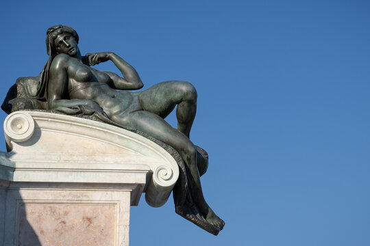 Bronze statue of a laying woman in a public square of Florence, Italy