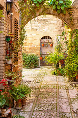 Floral alley with arch in italian  beautiful little town of Spello, Perugia. Umbria region.