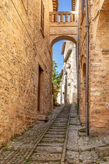 Fototapeta na wymiar Traditional italian medieval street in the historic center of beautiful little town of Spello, Perugia, Umbria region
