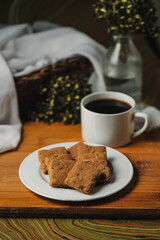 Crunchy cookies biscuits served in plate with black coffee isolated on table side view of american cafe baked food